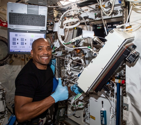 Victor Glover repairing machinery aboard the International Space Station