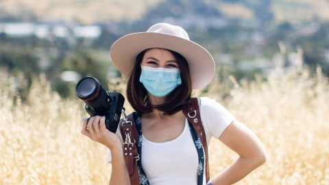 Photographer and Cal Poly alumna Asia Croson wearing mask holding camera