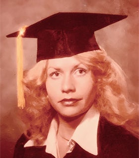 A portrait of alum Nathalie Taylor (English, '79) in cap and gown. 
