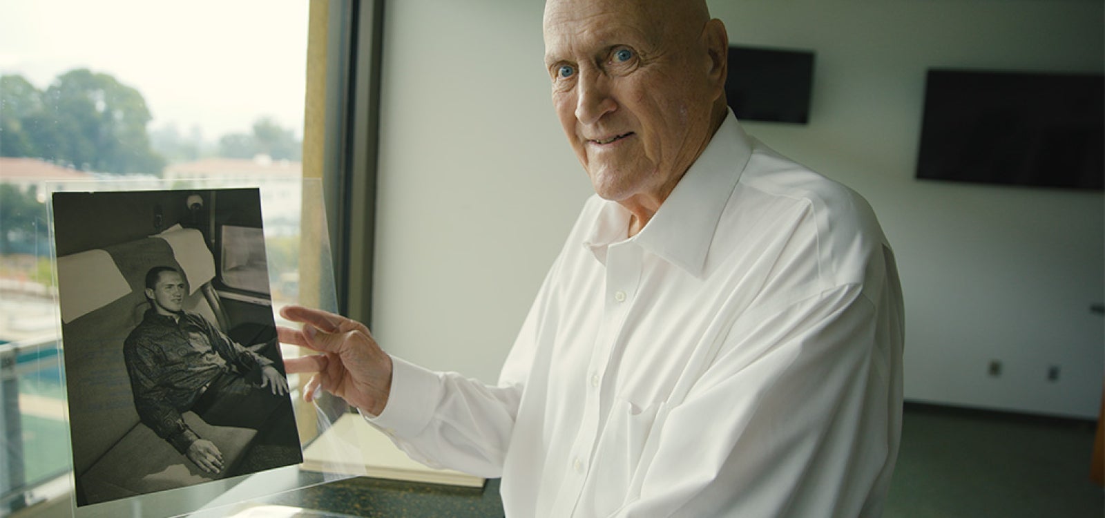 Alumnus Fred Brown holding a photo of himself during his time at Cal Poly. 