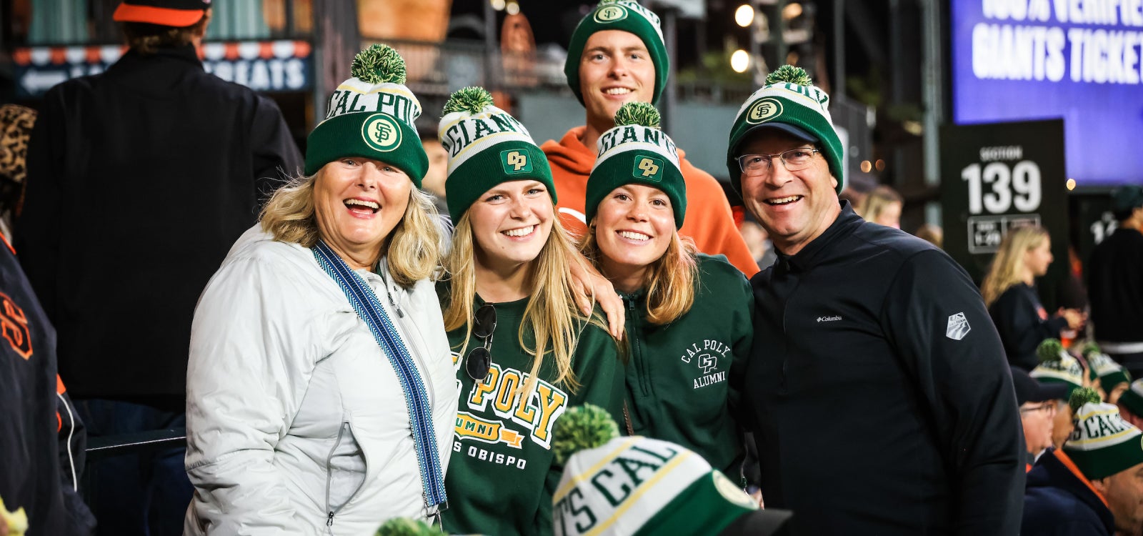 Alumni wearing the Cal Poly x Giants beanies.