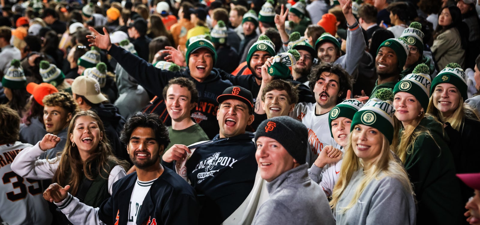 Alumni in the stands at Oracle Park wearing their limited-edition beanies. 