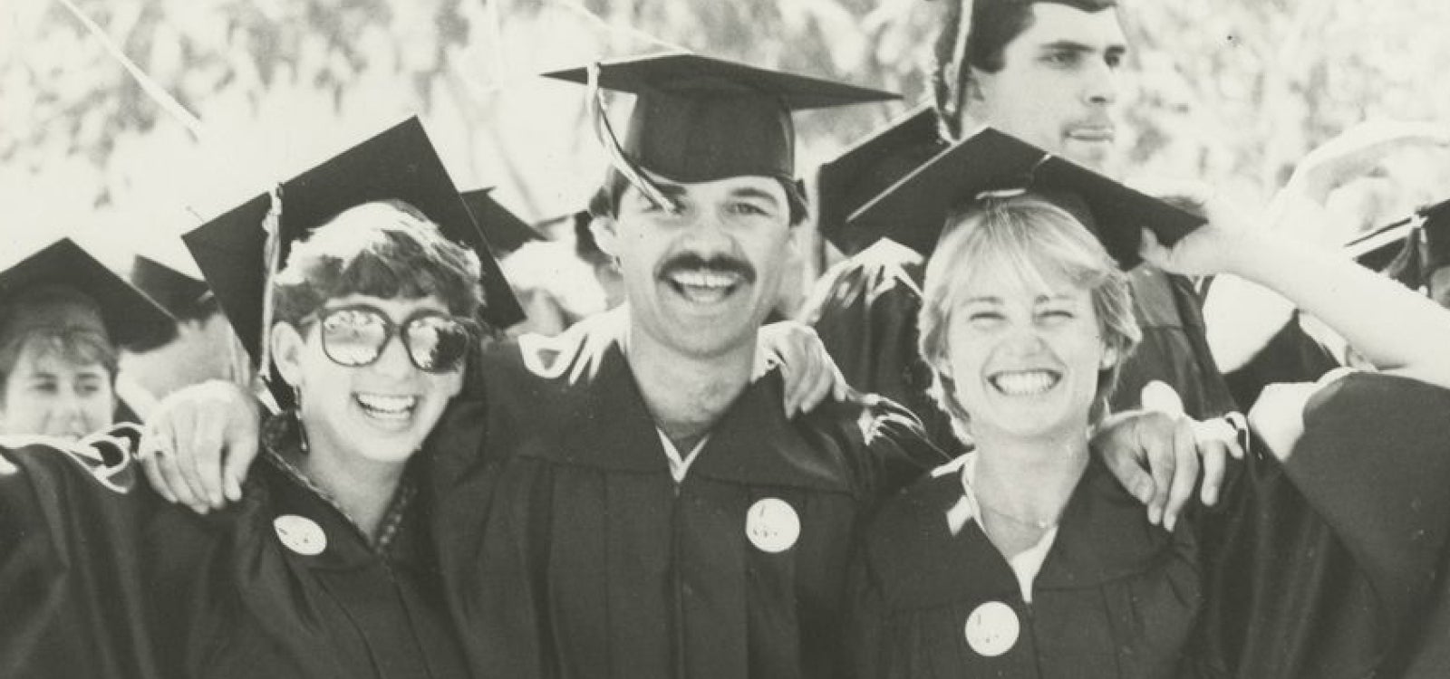 Graduates in 1985 smiling for the camera.