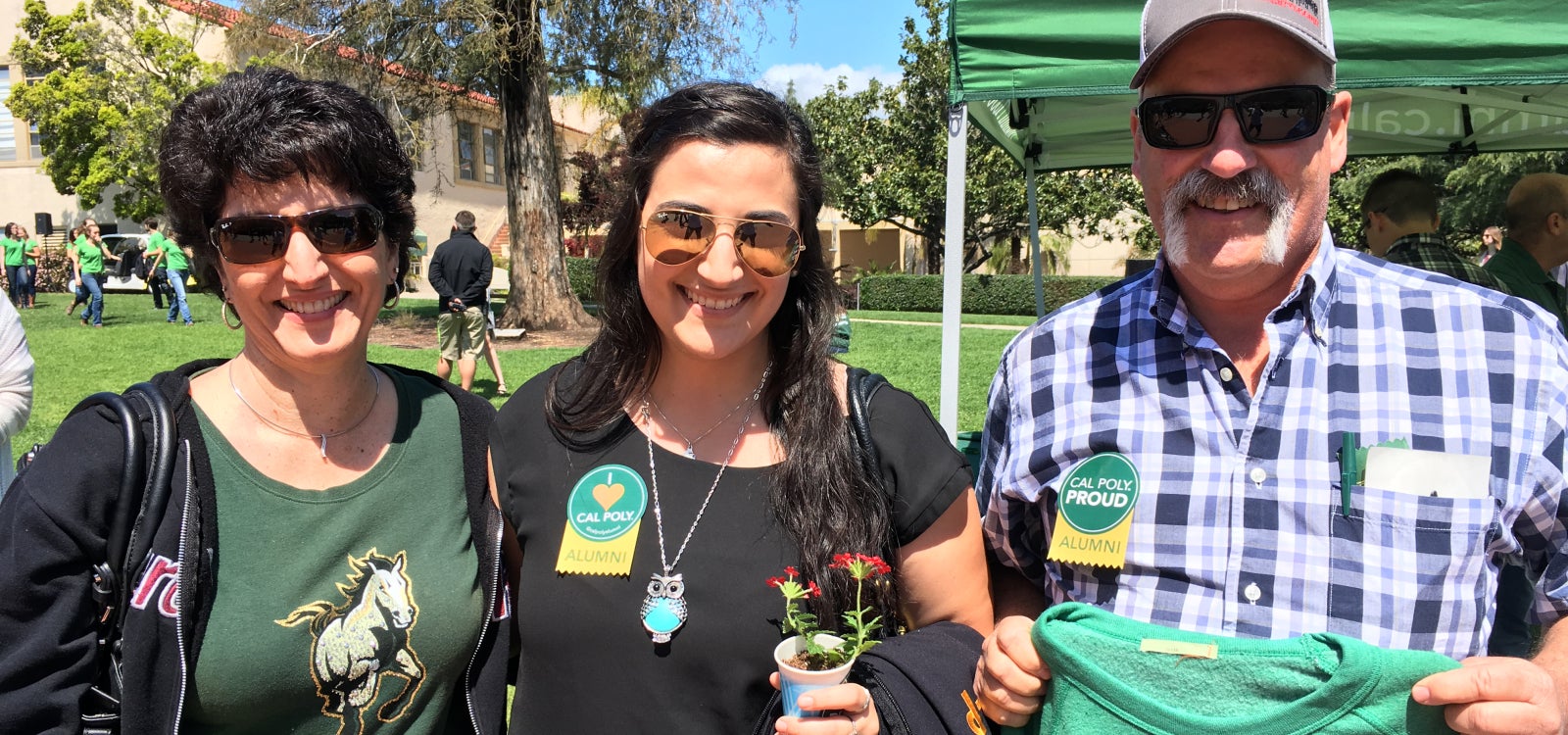 Alumni and student smiling for the camera.