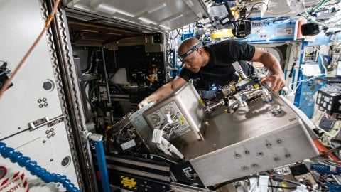 Victor Glover repairs hardware aboard the space station