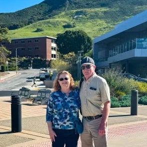Alum Mark Kent and Marley Kent standing at campus in front of the Cal Poly "P."