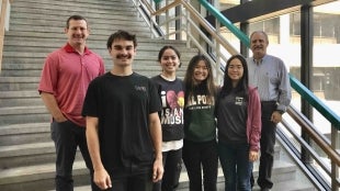 Alumnus Jason Wheeler with students and a professor