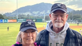 Alum Kevin Schindler and wife Vickie smile for a photo at a Cal Poly Baseball game.