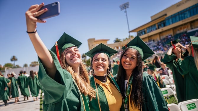 Graduates taking a selfie.