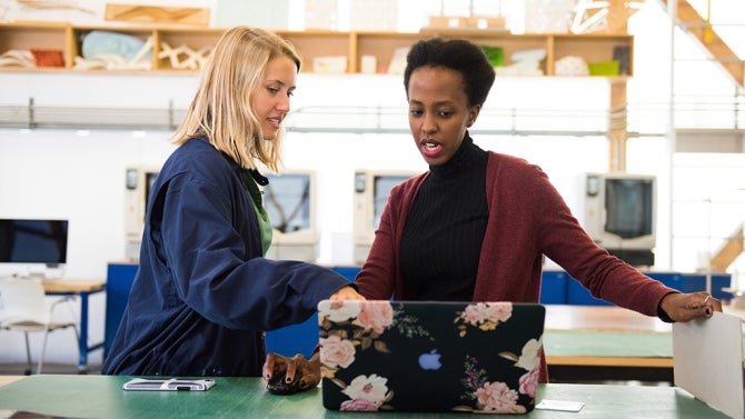 Student and mentor taking in front of a laptop