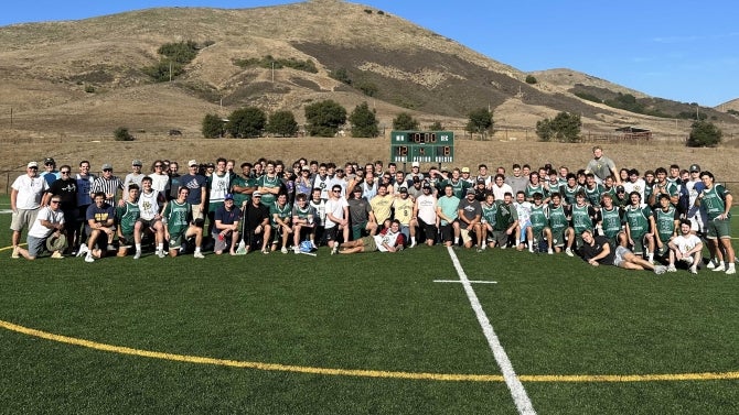 Cal Poly Men's Lacrosse team cheering and smiling for the camera.