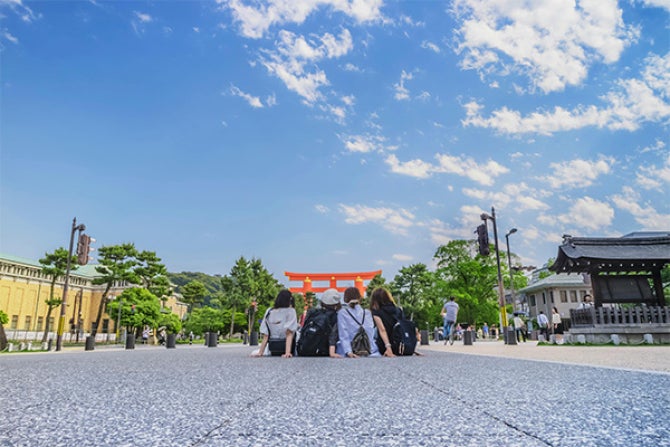 People sitting in front of Japanese shrine.