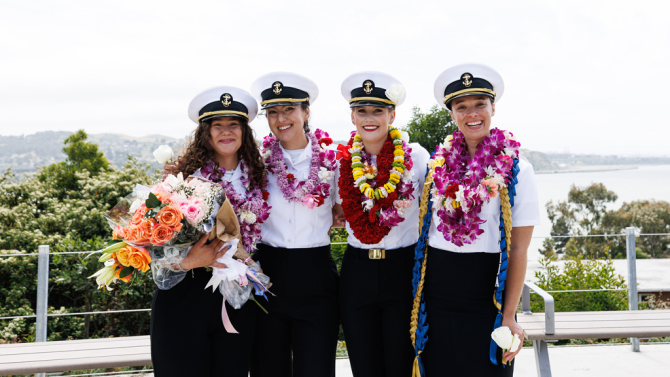 Four people pose at Maritime graduation