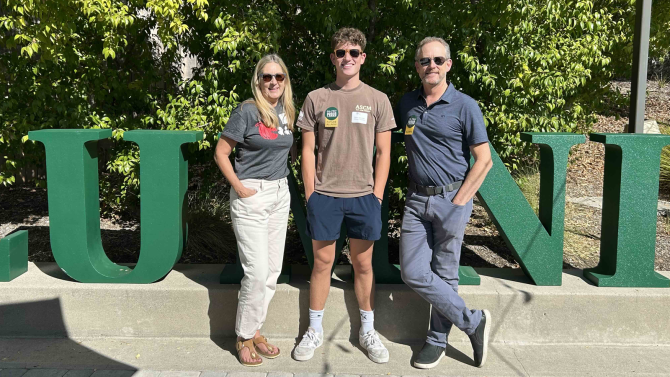 Three people smile for the camera