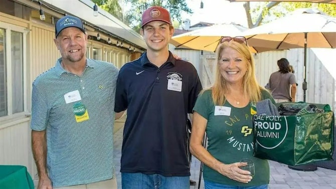 Three people smile for the camera