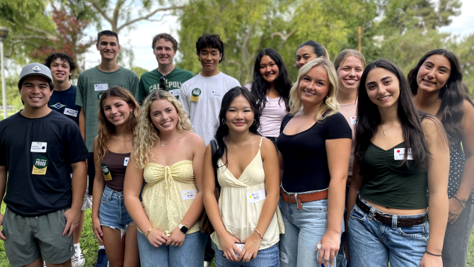 A group of people stand and smile for the photo