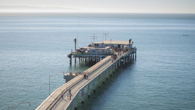 Image of people walking on the Cal Poly Pier in Avila. 